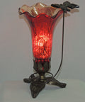 Vintage-style table lamp with mercury red lily glass shade and antique bronze finished base with suspended butterfly. 