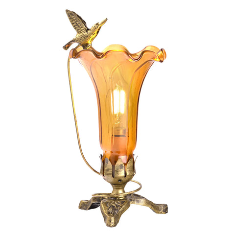 Amber lily glass lamp with a decorative soaring hummingbird bird on a dark and light bronze 3 leaf base.