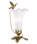 White lily glass lamp with a decorative soaring hummingbird bird on a dark and light bronze 3 leaf base.