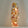 A tall, narrow white decorative lamp or vase with a warm internal light, decorated with colorful painted flowers and butterflies, set against a soft white  background.