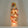 A tall, narrow frosted glass candle vase lamp featuring hand-painted hummingbirds, butterflies, and yellow flowers, illuminated from within against a neutral background.
